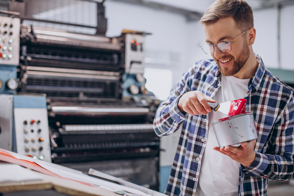 sm man working printing house with paper paints